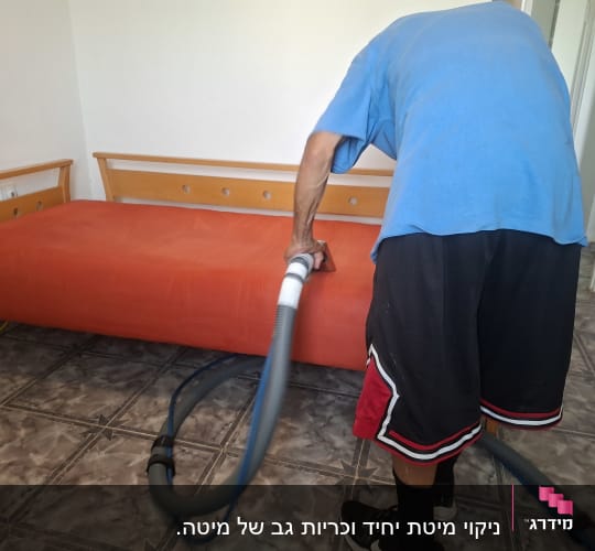 אדם מנקה ספה עם שואב אבק